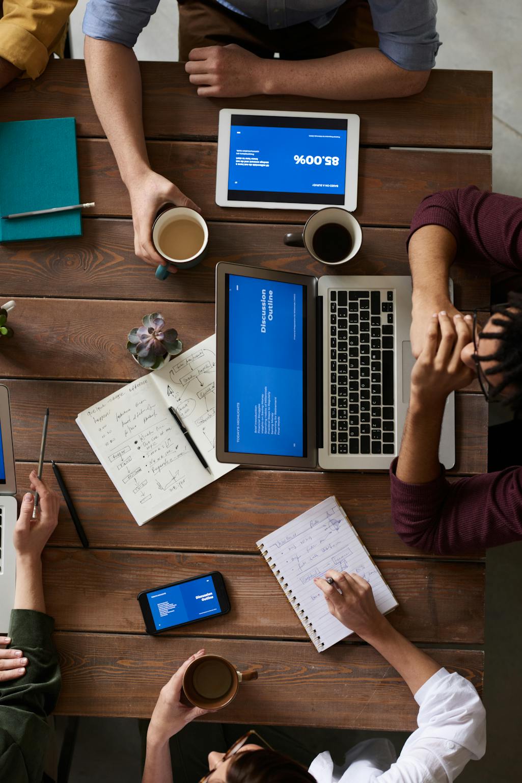 Team workspace at BiK Solution – laptops and coffee mugs during a digital project meeting with an AI phone agent test taking to a customer call